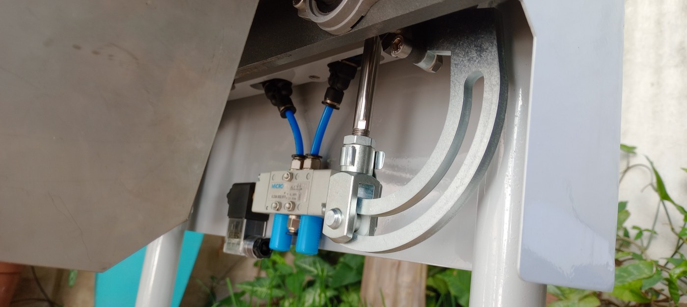 Detalle del mecanismo ya fabricado: cilindro neumático, guías curvas y electroválvula montados bajo la estructura